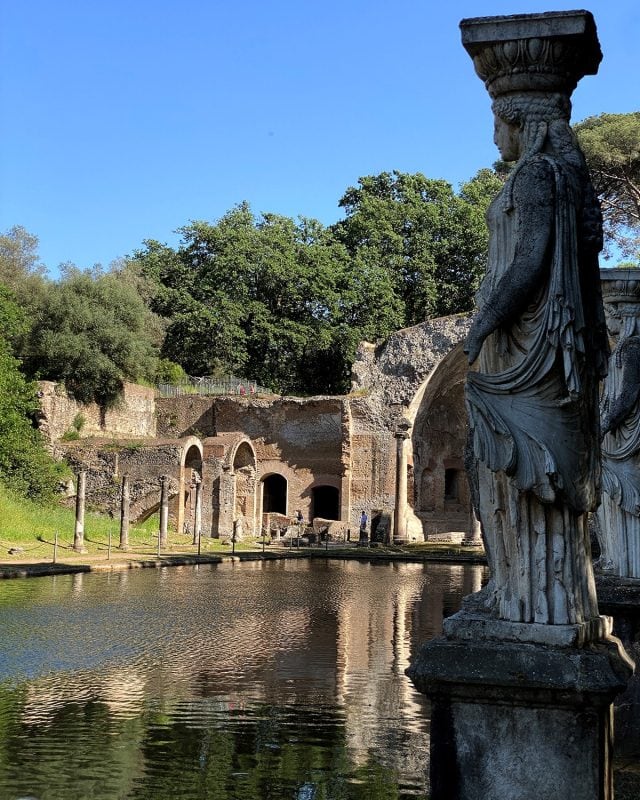A stone caryatid statue overlooking the Canopus pool and Roman ruins at Hadrian’s Villa.