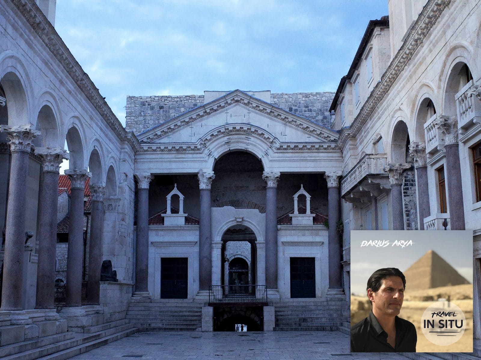 Ancient Roman architecture with a central archway and columns; inset features a travel show poster with a man and pyramid in the background.