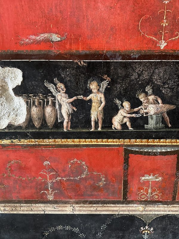 Roman fresco depicting winged putti interacting with pottery vessels against a black and red background.